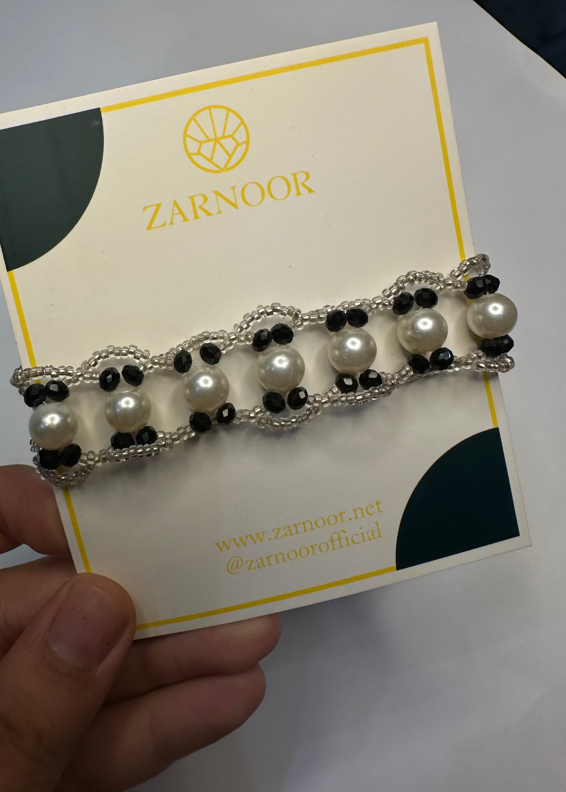 Pearl and black beaded bracelet on a Zarnoor branded card