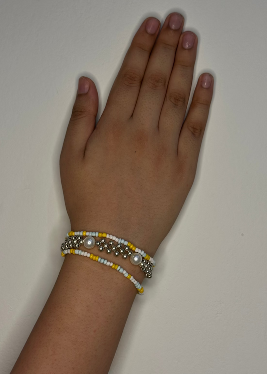 Hand wearing a bracelet on a plain background